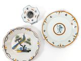 two plates and a candle holder are sitting on a white surface