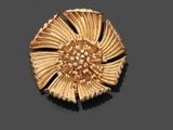 broche en forme de fleur plaquée or sur un fond noir