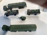 several toy army vehicles are on display on a white surface