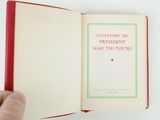 someone is holding a book with a red cover and a green cover