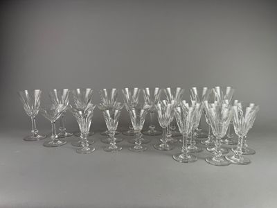 douze verres à vin en cristal alignés sur une surface grise