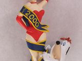 une figurine représentant une femme et un chien posée sur une table