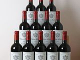 des bouteilles de vin rouge sont posées sur une table en bois devant un mur blanc