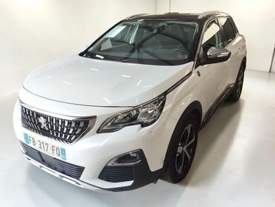 La voiture blanche est garée dans une pièce blanche au sol blanc.