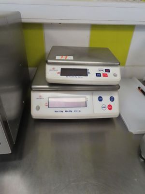 two electronic devices sitting on top of a metal counter