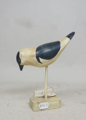 un oiseau en bois posé sur un socle en bois