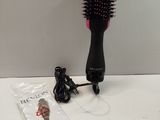 a hair brush that is sitting on a table next to a book