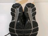 pair of black and silver running shoes sitting on top of a white table