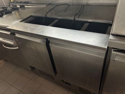une cuisine avec un plan de travail en inox et un évier