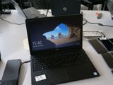 un ordinateur portable posé sur une table, à côté d'un téléphone portable