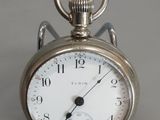 une montre de poche en argent exposée sur une table