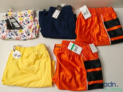cinq paires de maillots de bain pour garçons sont alignées sur une table