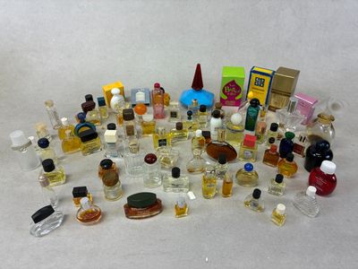 de nombreux petits flacons de parfum posés sur une surface blanche