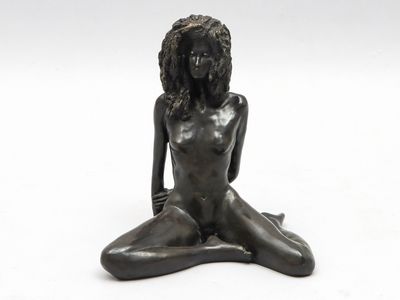 a statue of a woman sitting on the ground with her legs crossed