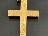 a close up of a gold cross on a black surface
