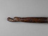 a close up of a knife with a wooden handle on a white surface