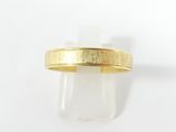 gros plan d'une bague en or sur une surface blanche