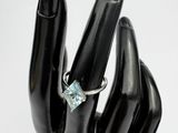 a hand with a ring on it that has a blue stone on it