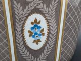 a vase with a blue flower on it sitting on a table