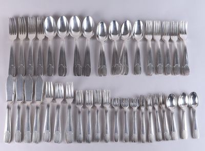 a lot of spoons and forks laid out on the table