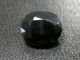 a close up of a black diamond on a black surface