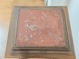 a small table with a red marble top on it