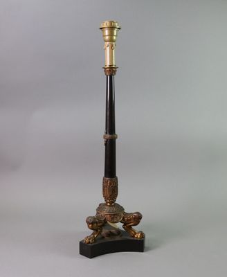 an antique brass and black lamp on a marble base