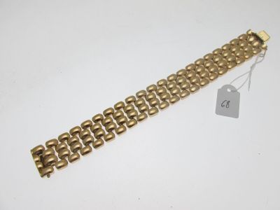 un bracelet en or sur fond blanc, avec une étiquette de prix