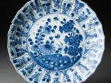 une assiette bleue et blanche ornée de fleurs et d'oiseaux