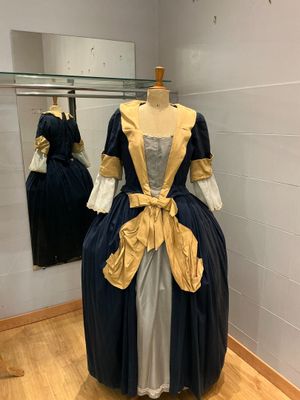une robe exposée dans un musée, avec un miroir en arrière-plan