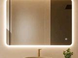 une salle de bains avec un lavabo, un miroir et une plante posée sur le plan de travail