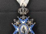 une médaille bleue et blanche sur laquelle figure une couronne