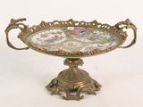 a gold plate with flowers on it on a stand