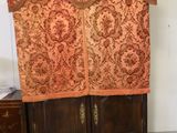 a very tall cabinet with a curtain on top of it