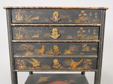a small black chest of drawers with birds and flowers on it