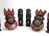 plusieurs figurines en bois de formes et de tailles variées posées sur une surface blanche