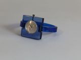un anneau bleu sur lequel figure une horloge, posé sur une table