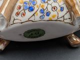 a white vase with a gold and blue design on it