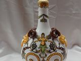 un vase blanc et doré orné d'un oiseau