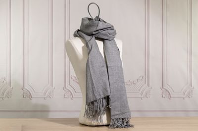 a gray scarf on a mannequin in a room