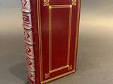 a red book sitting on top of a stack of books