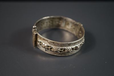une vieille bague en argent posée sur une table, sur fond noir