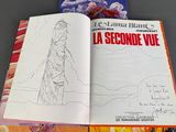 three books on a table with a drawing of a woman on the cover
