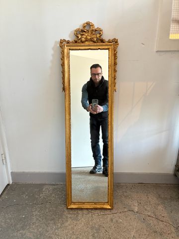 Miroir vertical cadre doré, décor de nœud enrubanné. H 120 L 32 c