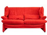 Le canapé rouge est posé sur une surface blanche.