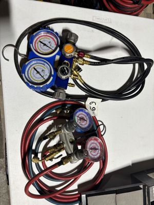 two gauges and a couple of hoses sitting on a table