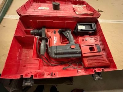une boîte à outils rouge contenant une perceuse et d'autres outils