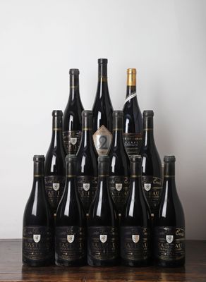 Des bouteilles de vin sont alignées sur une table devant un mur blanc.