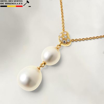 un pendentif composé d'une perle blanche et de diamants, monté sur une chaîne en or