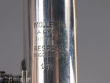 a close up of a silver flute with a black label on it